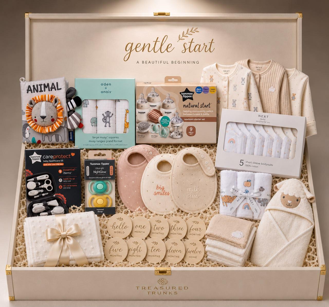 The Gentle Start trunk filled with cream babygrows, muslin squares and milestone discs